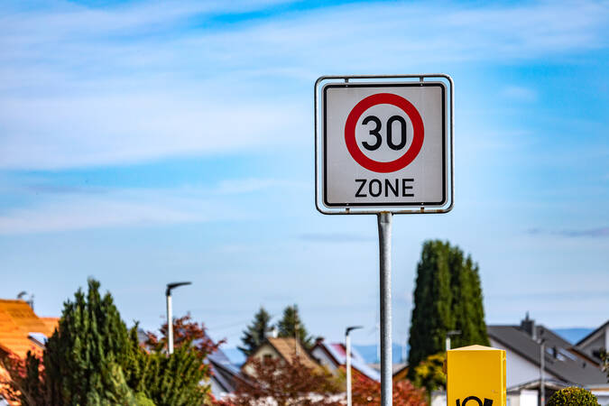 Ein Verkehrsschild, das auf den Beginn einer Tempo-30-Zone hinweist vor einem blauen Himmel.